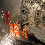 Miners hold a statue of Saint Barbara after drill machine broke through the rock at the construction site of the NEAT Gotthard Base Tunnel